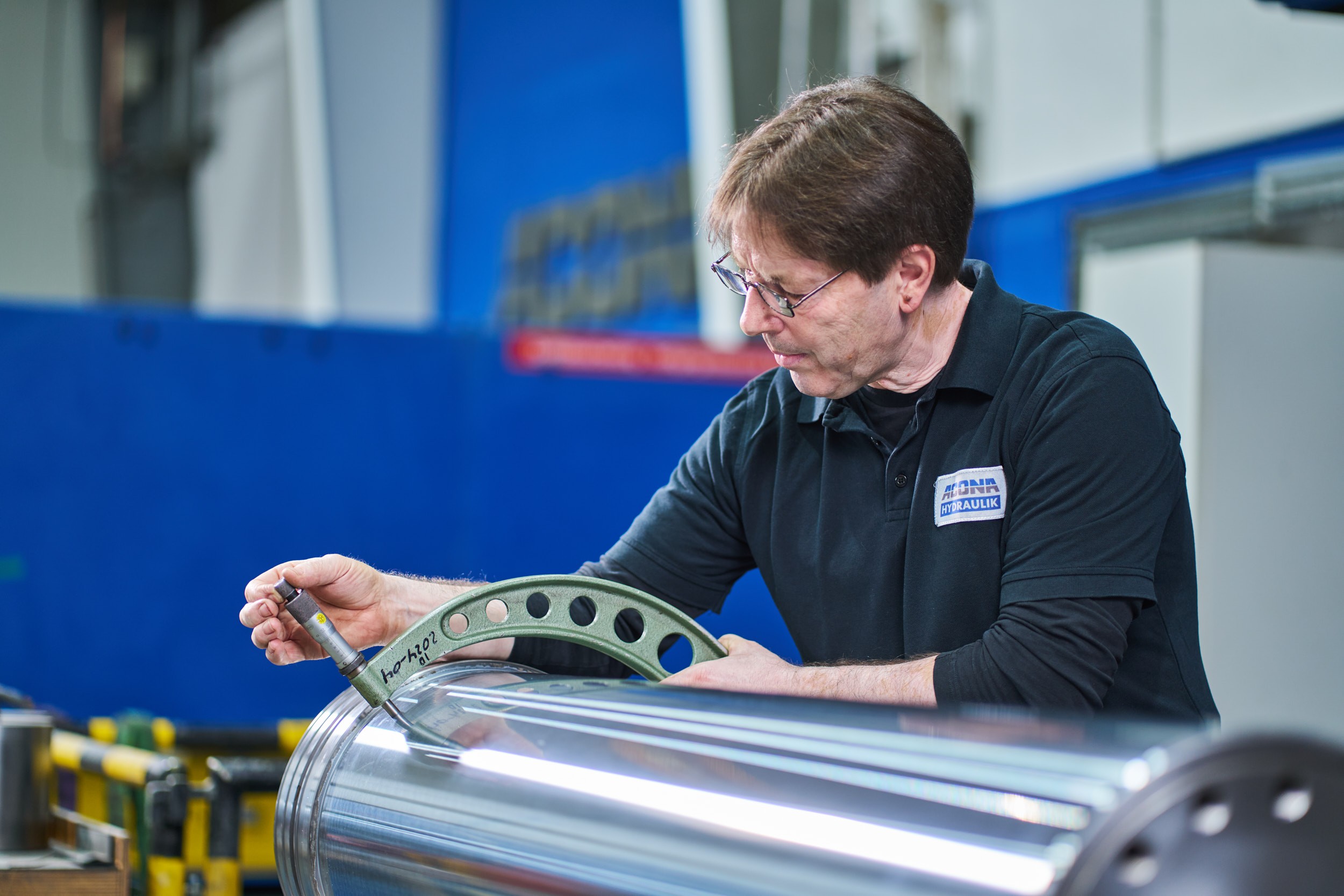 Ein Mitarbeiter von ACONA bei der Arbeit an einem Hydraulikzylinder