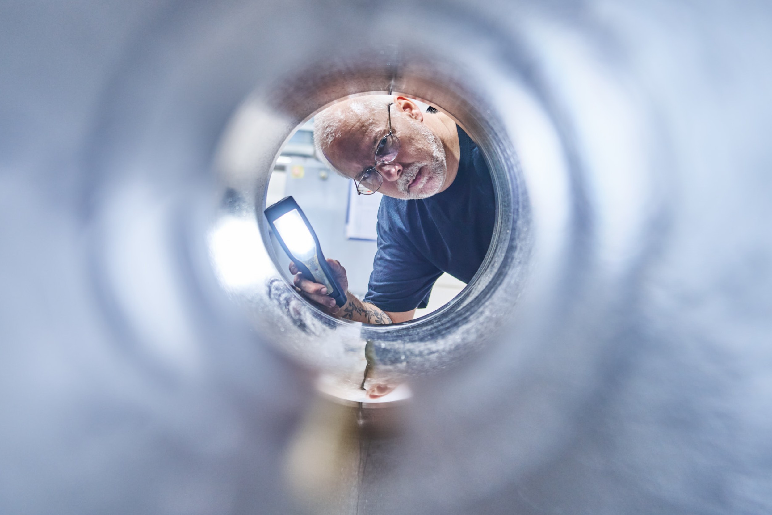 Das Innere eines Zylinders wird von einem ACONA Mitarbeiter auf Fehler &uuml;berpr&uuml;ft