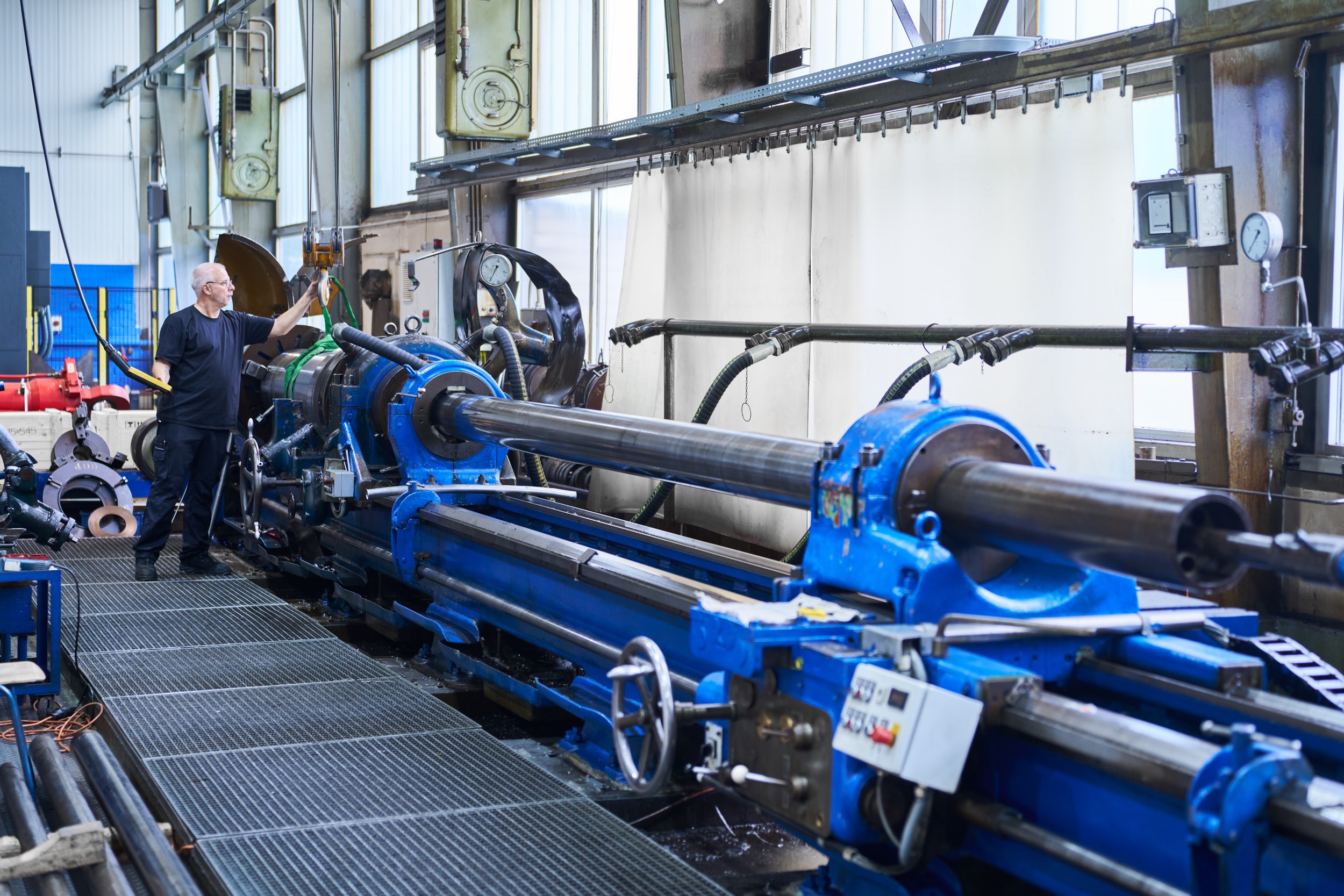 In einer Halle von ACONA bedient ein Mitarbeiter eine Maschine
