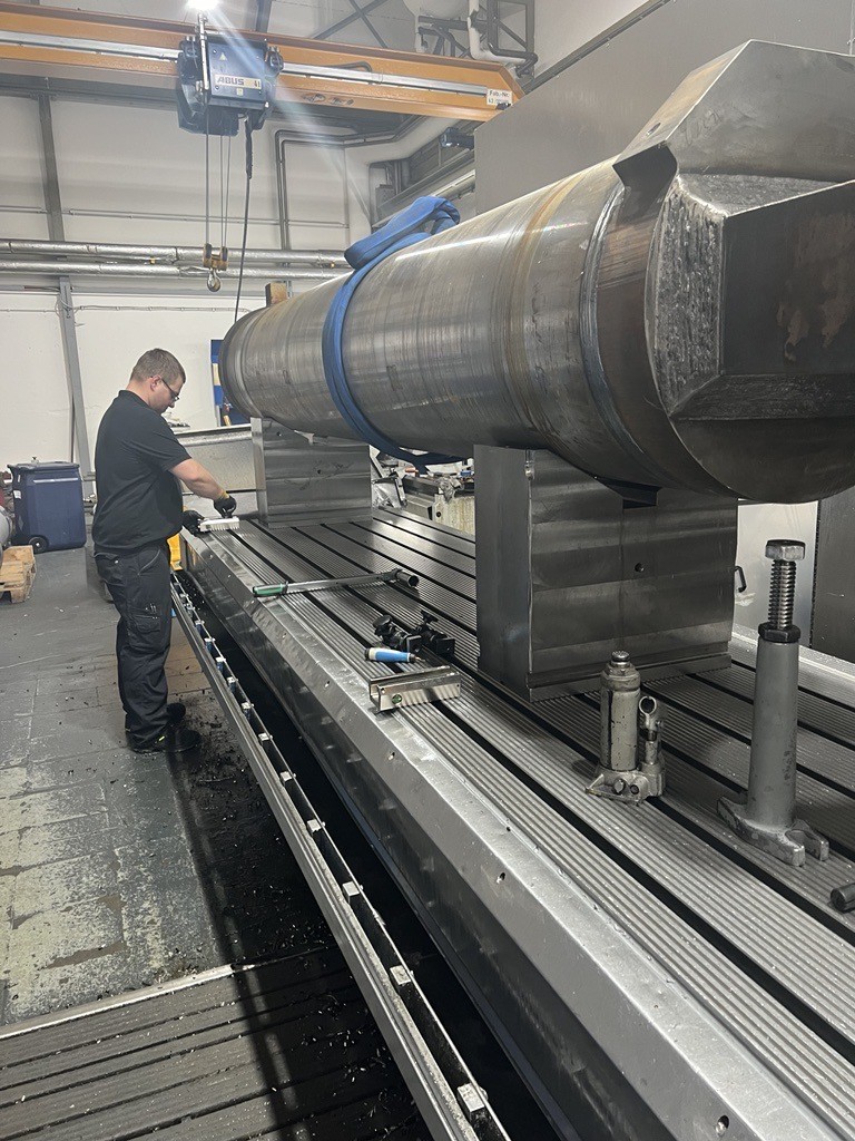 Ein Mitarbeiter von ACONA stellt eine Maschine zur Bearbeitung von Bauteilen f&uuml;r Hydraulikzylinder ein